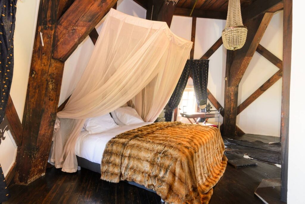 bedroom with a canopy bed and sheer curtains