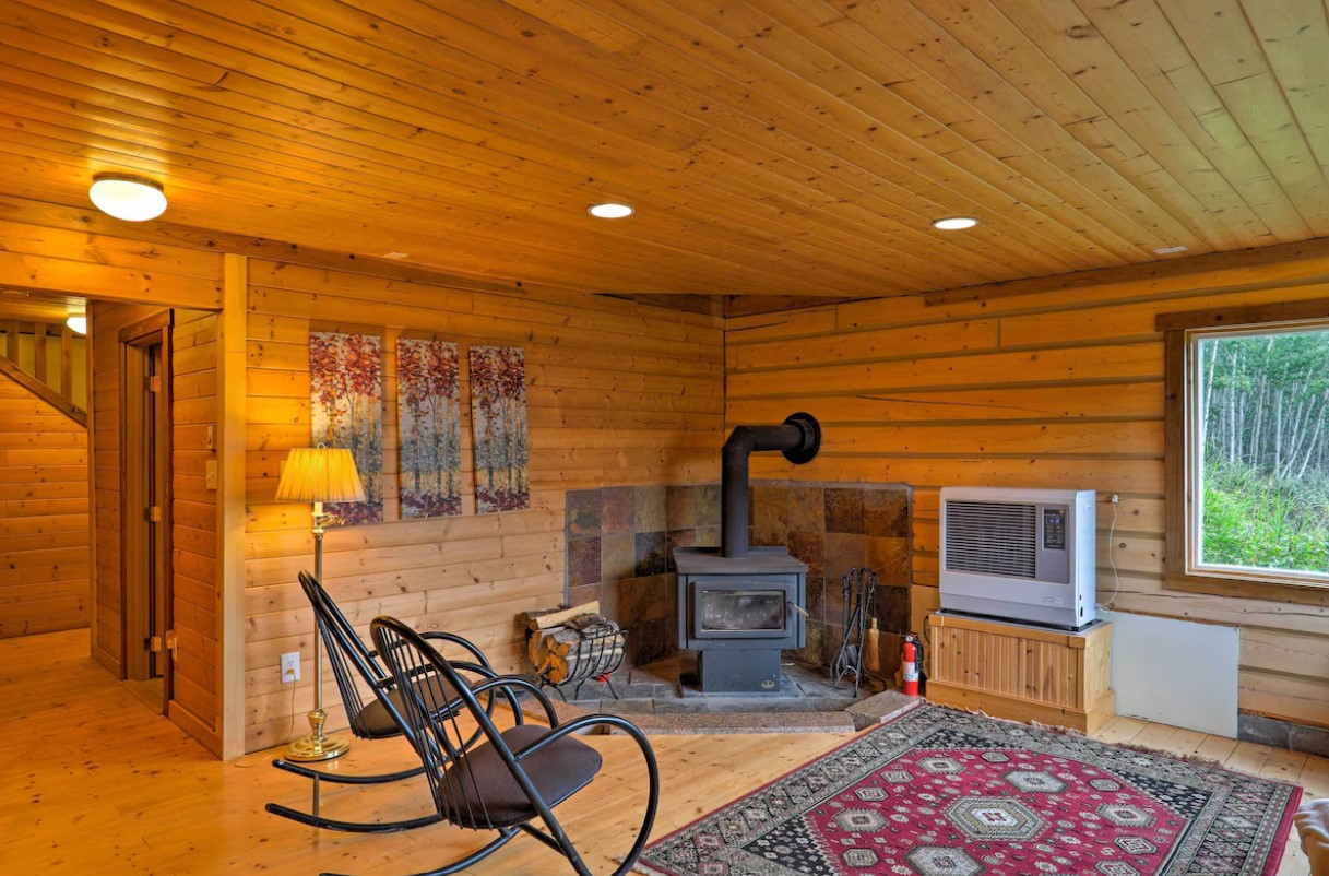 area with a small fireplace, rocking black chairs and a patterned carpet