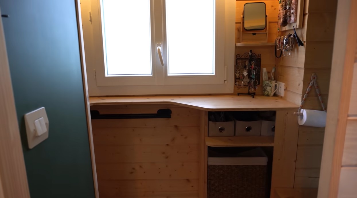 bathroom with a bult in wooden countertop, window above it