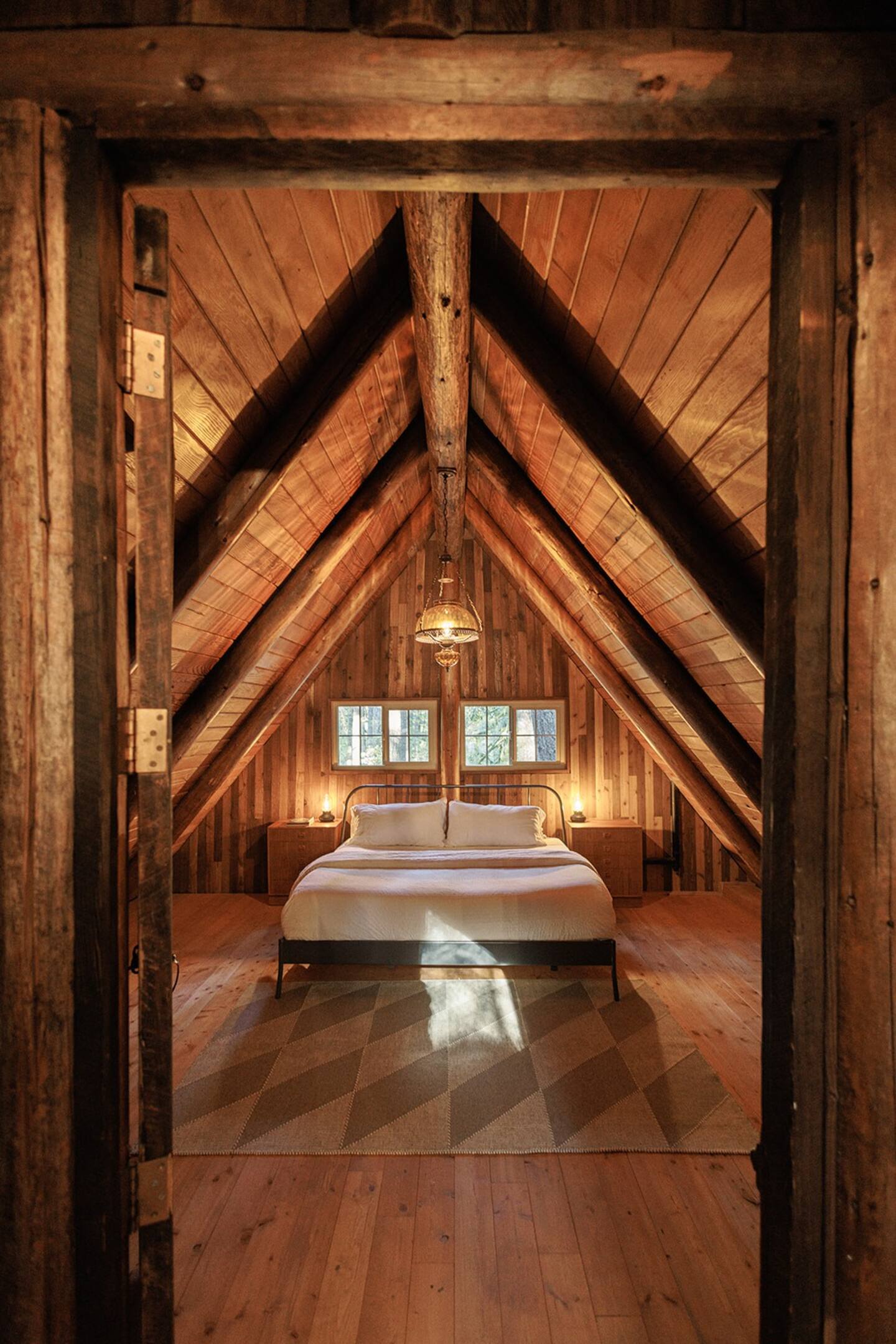 bedroom with a bed, chandelier above, wooden walls, a frame