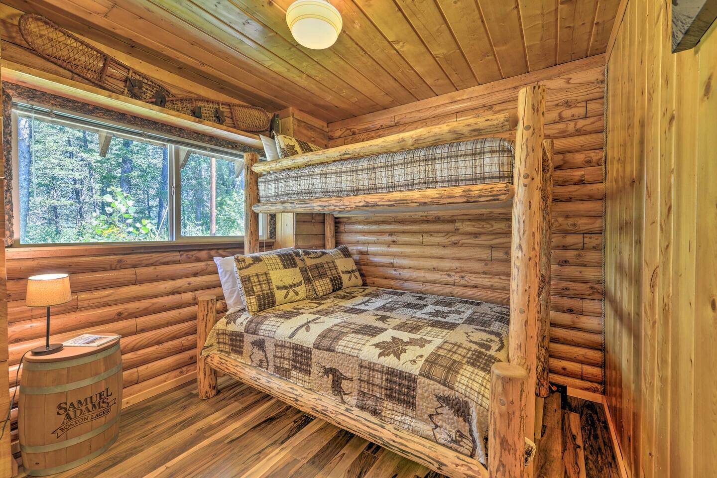 bedroom with bunk beds, wooden walls and a barrel nightstand