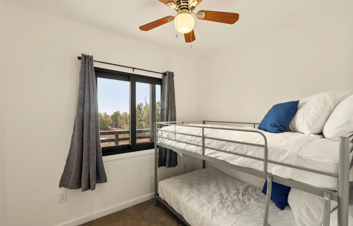 bedroom with bunk beds and a mirror and a ceiling fan