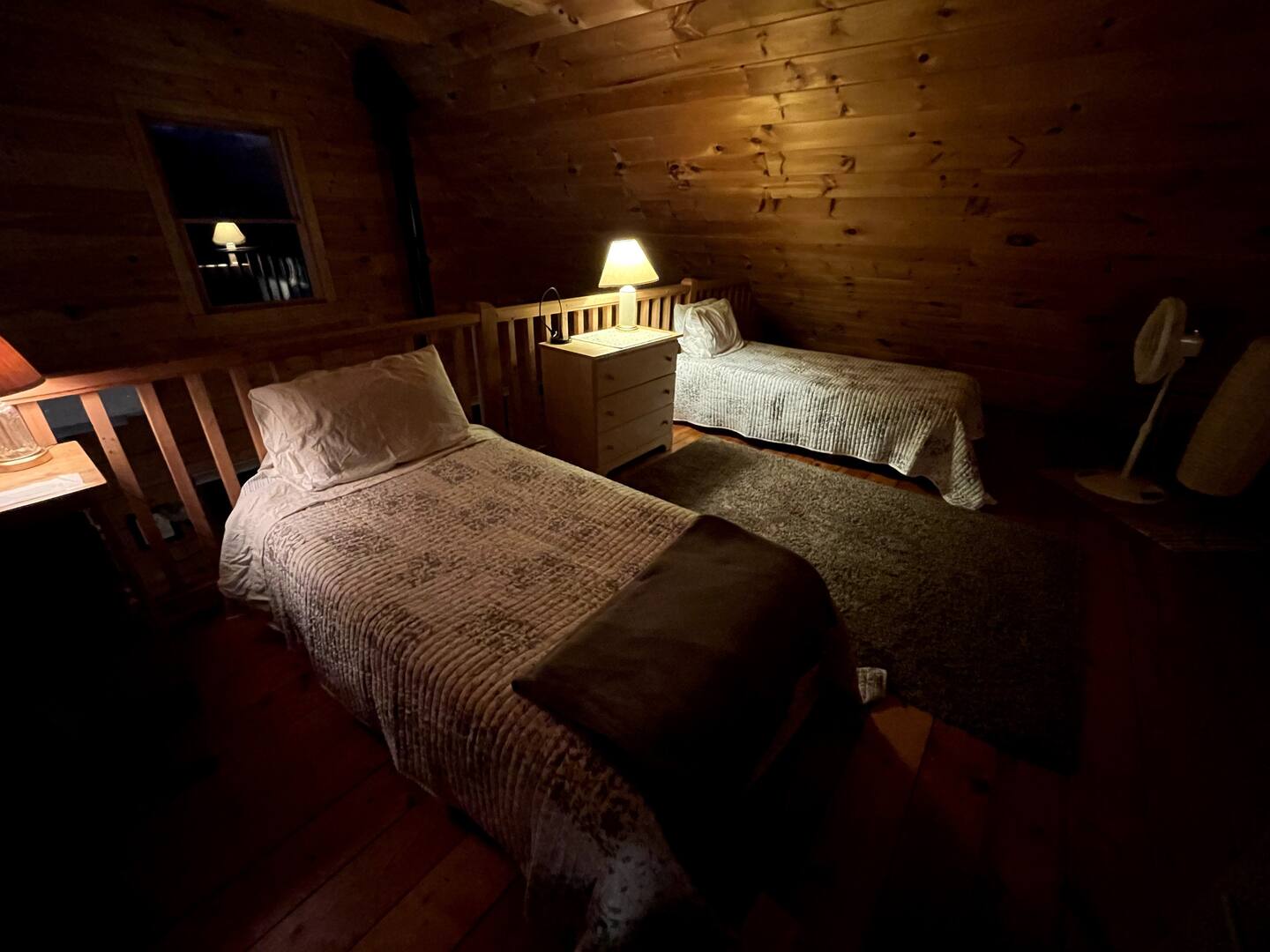 loft bedroom with twin beds, bedside tables with lamps