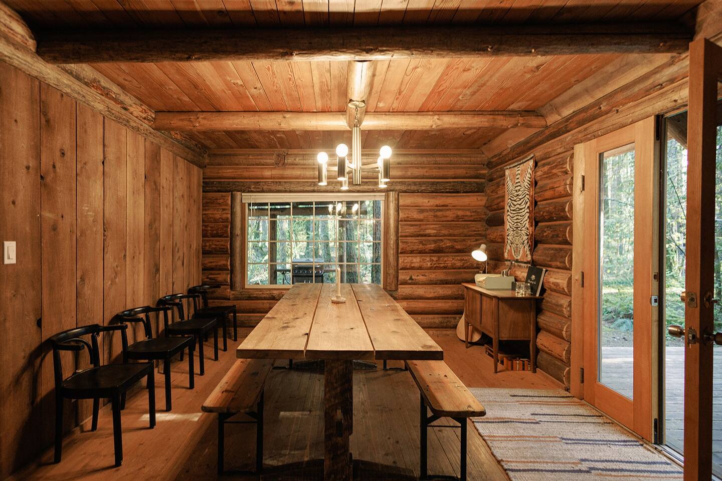 dining room with a long wooden dining table and wooden walls