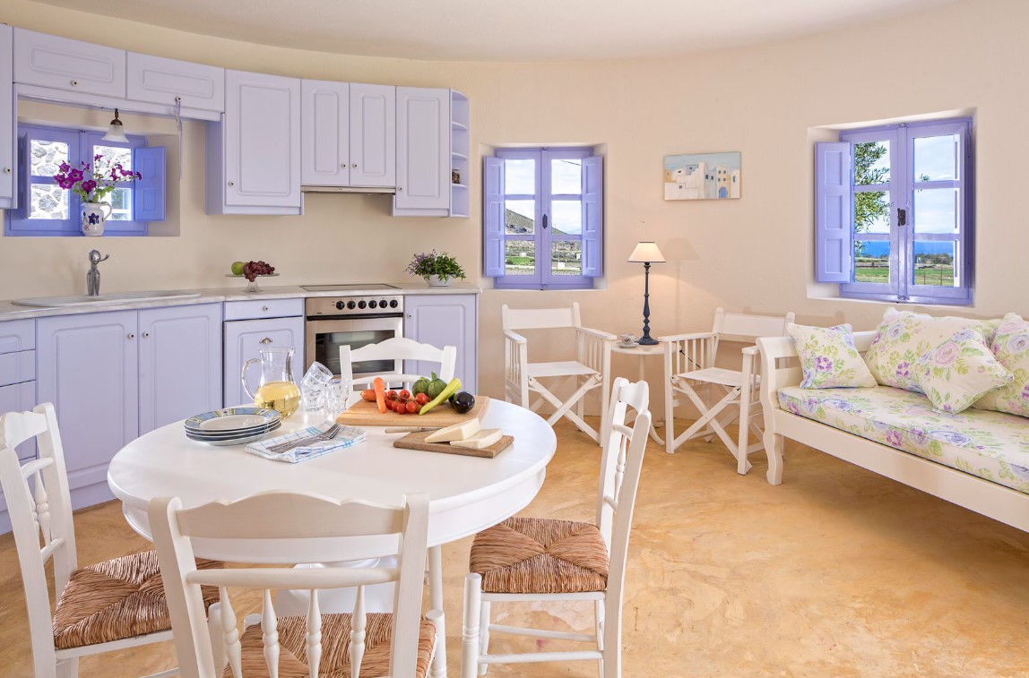 pastel kitchen with lavender cabinets, white round table, white chairs with woven seats, lavender windows