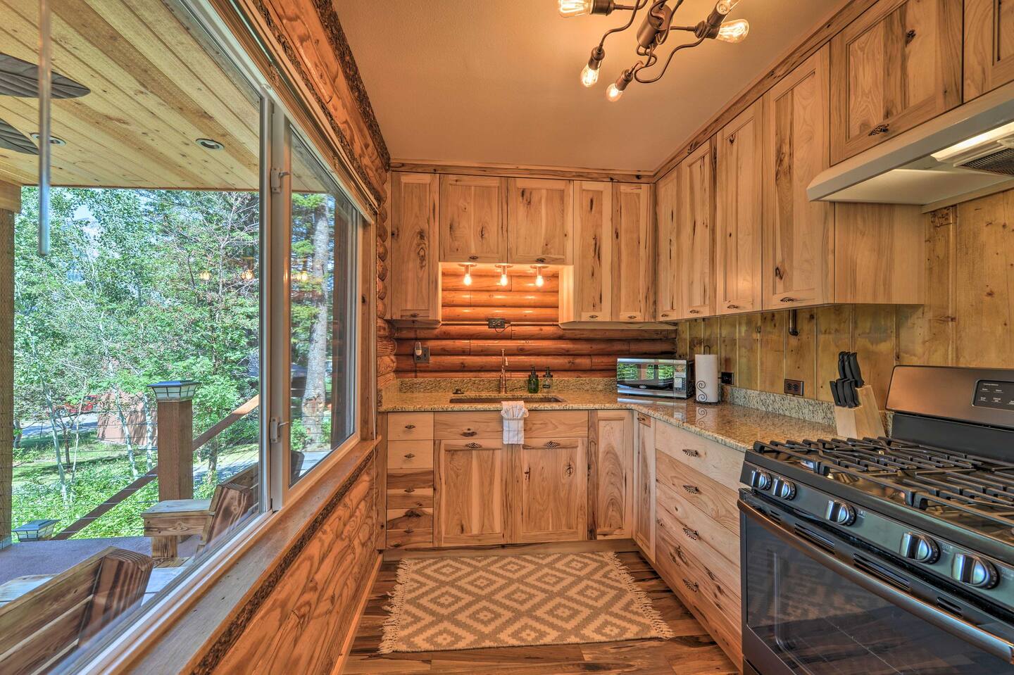 kitchen with wooden cabinets, wooden walls, large window