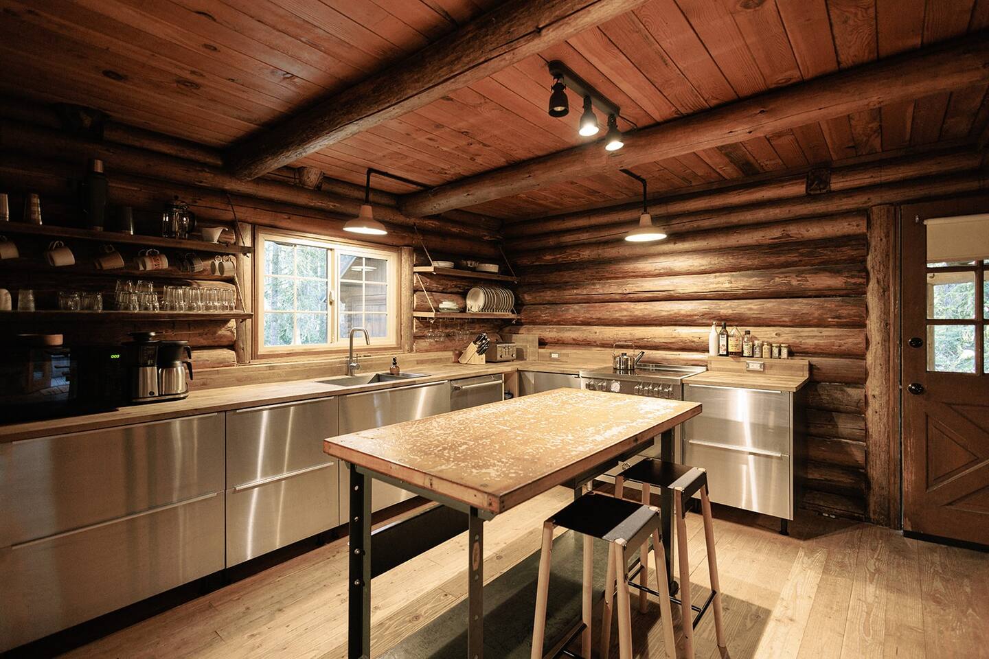 kitchen with an l-shaped countertop, island with two bar stools, open shelving