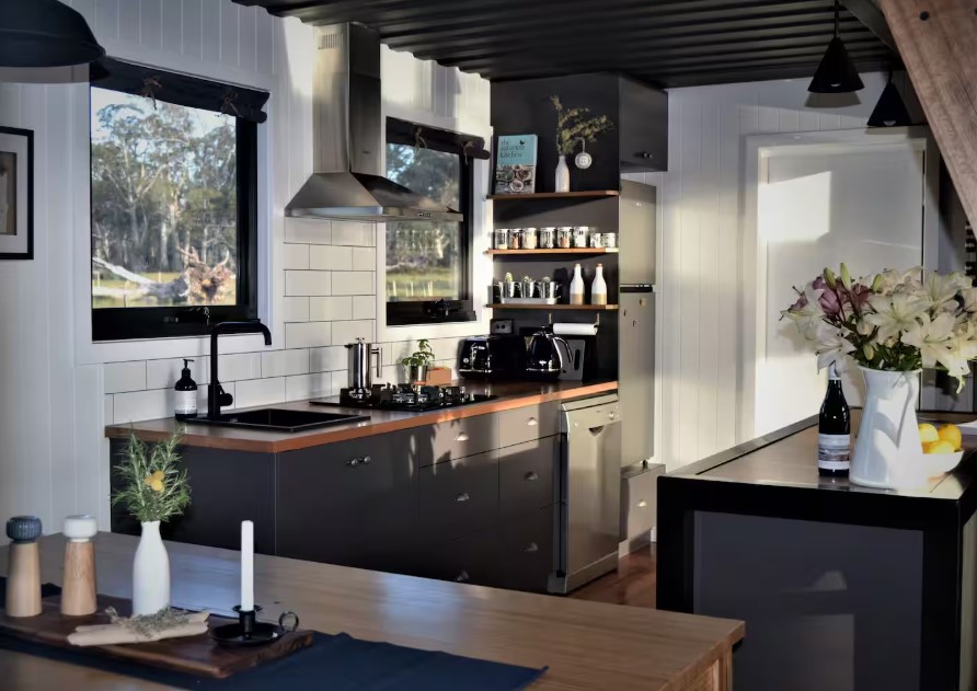 kitchen with black cabinets, wooden countertop, white walls