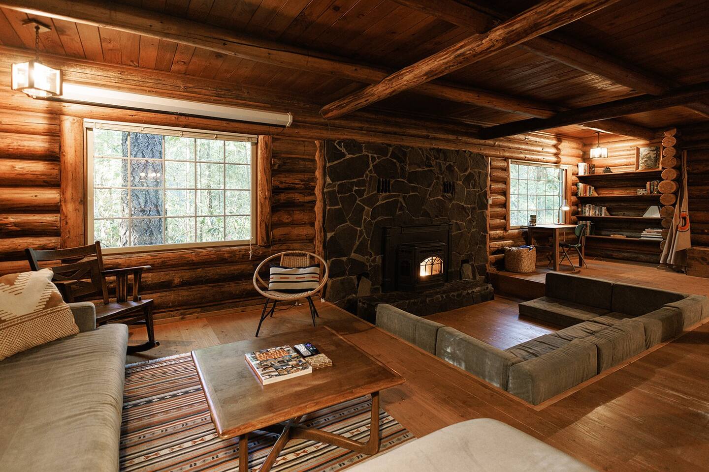 living room with a sectional, sunken seating area with a fireplace, huge window