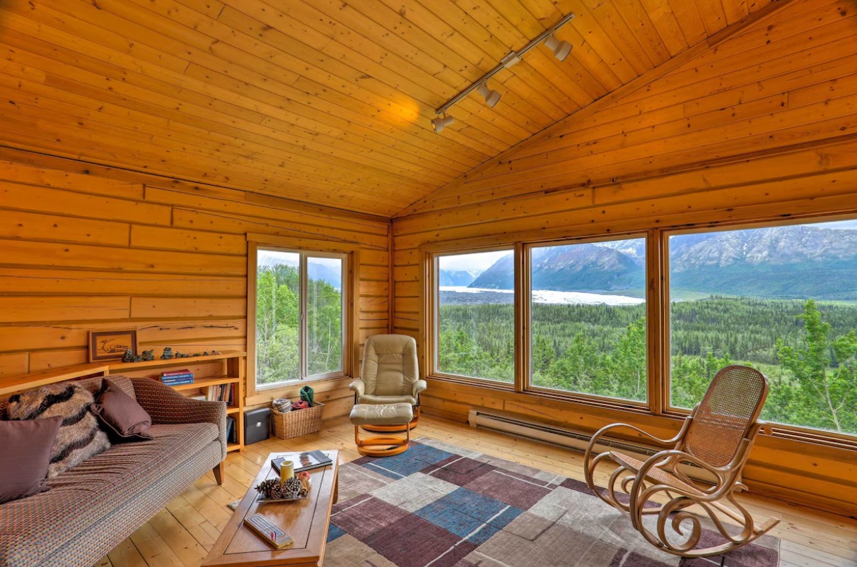 living room with big windows, brown walls, brown couch, rocking chairs