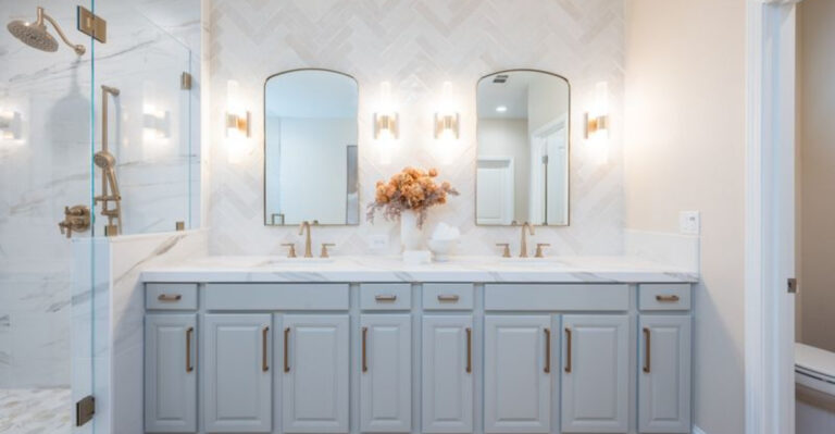 bathroom in white and gray/blue cabinets and two mirrors