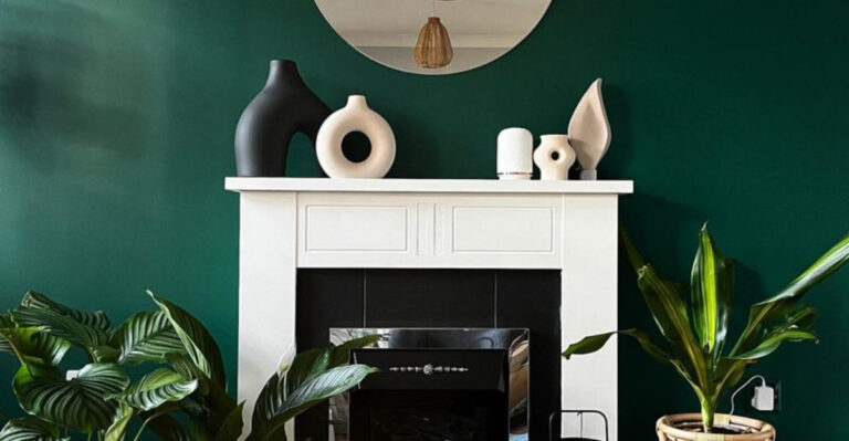 living room with a dark green wall behind the white fireplace