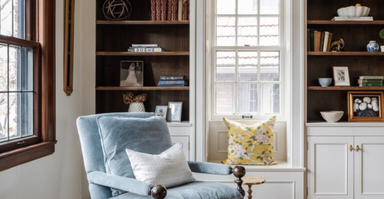 blue armchair next to built-in bookshelves