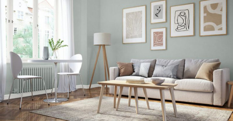 living room with a gray couch, brown table, white table next to the window, minimalist art