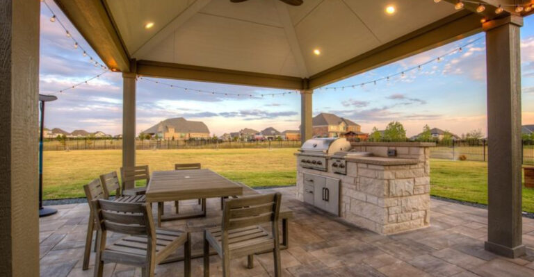 outdoor living space with a table and chairs and a grill
