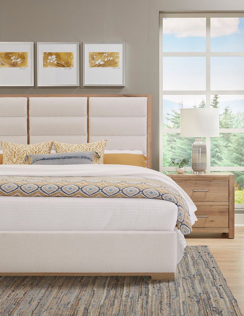 A Large White Upholstered Bed with Wooden Accents