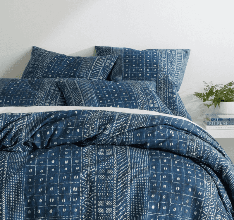 Mix dark and faded denim hues in layered bedding
