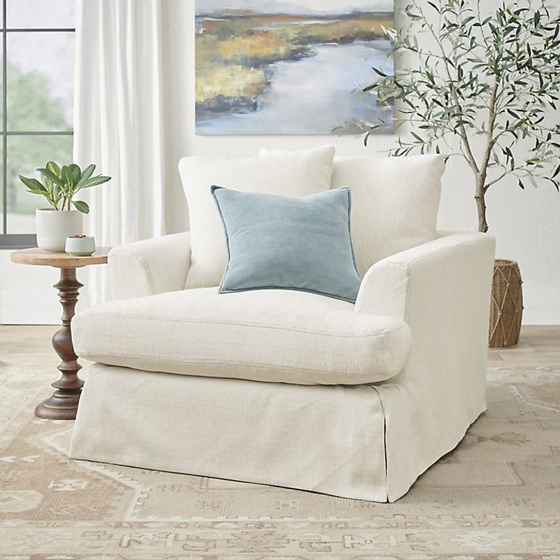 White Slipcovered Chairs with Blue Throw Pillows