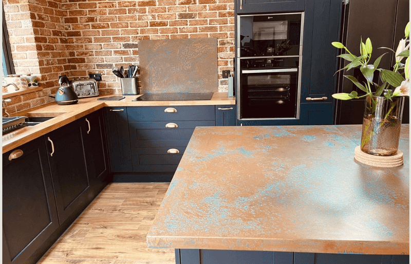 Warm Teal Cabinets Below a Patinated Copper Counter